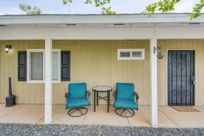 two blue chairs and a table on a porch at Coulterville Home with Gazebo Near Lakes and Hiking! in Coulterville