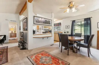 a dining room with a table and chairs and a kitchen at Lincoln Lodge cabin in Groveland
