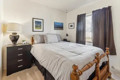a bedroom with a bed with a dresser and a window at Lincoln Lodge cabin in Groveland
