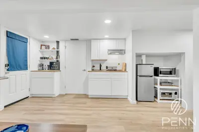 a kitchen with white cabinets and a refrigerator at Midtown Gem with Secret Speakeasy in Sacramento