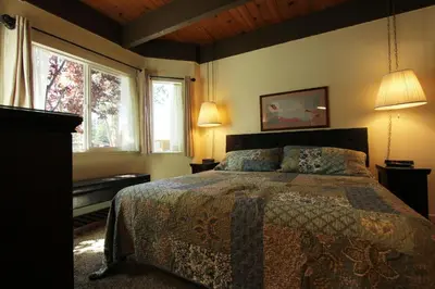 a bedroom with a bed with two lamps and two windows at TKC0604 - Betty Ann's Place condo in South Lake Tahoe