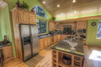 a kitchen with wooden cabinets and a stainless steel refrigerator at COH1669 - Hawk's View Hideaway home in South Lake Tahoe