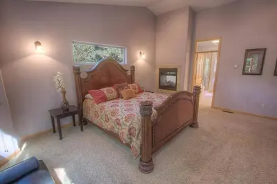 a bedroom with a large wooden bed with pink pillows at COH1669 - Hawk's View Hideaway home in South Lake Tahoe
