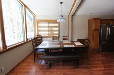 a dining room table with chairs and a refrigerator at COH1261 - Nature's Gem home in South Lake Tahoe