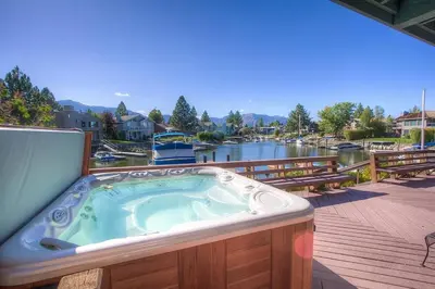a hot tub on a deck next to a river at TKH1226 - Emerald Lodge home in South Lake Tahoe