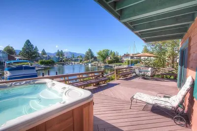 a deck with a hot tub and a chair at TKH1226 - Emerald Lodge home in South Lake Tahoe