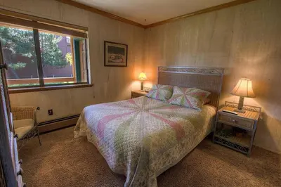 a bedroom with a bed and two lamps and a window at TKH1226 - Emerald Lodge home in South Lake Tahoe