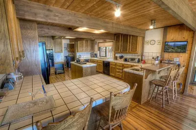 a large kitchen with wooden cabinets and a table at CYH1281- Tahoe Acres home in South Lake Tahoe