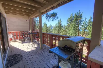 a grill on a deck with a table and chairs at HCH1217 - Pinehill Ponderosa home in South Lake Tahoe