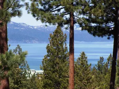 a view of a lake from between some trees at HCH1217 - Pinehill Ponderosa home in South Lake Tahoe