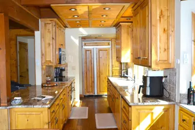 a large kitchen with wooden cabinets and wooden floors at Deer Lodge #1 Lake front in Bass Lake