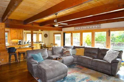 a living room with a couch and a kitchen at Deer Lodge #1 Lake front in Bass Lake