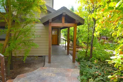 a walkway leading to a house with a wooden door at Deer Lodge #1 Lake front in Bass Lake