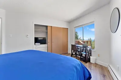 a bedroom with a blue bed and a balcony at HCH1083 - Mountain Serenity home in South Lake Tahoe