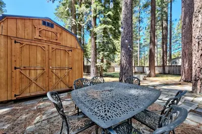 a table and chairs in front of a wooden barn at CYH0876 - Island Cabin cabin in South Lake Tahoe