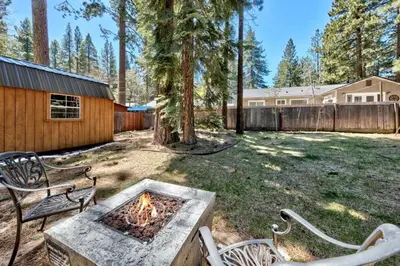 a backyard with two benches and a fire pit at CYH0876 - Island Cabin cabin in South Lake Tahoe