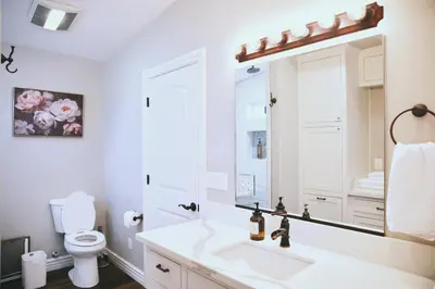 a white bathroom with a sink and a mirror at A Luxury Yosemite Retreat in Mariposa