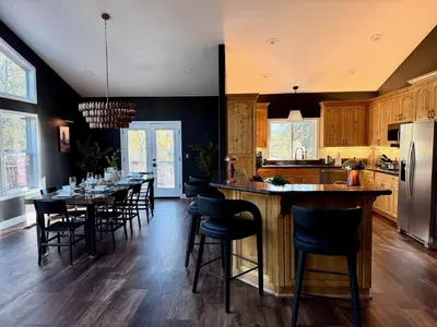 a kitchen with a long table and chairs in it at Elegant Blackwood Grove by Casa Oso in Mariposa