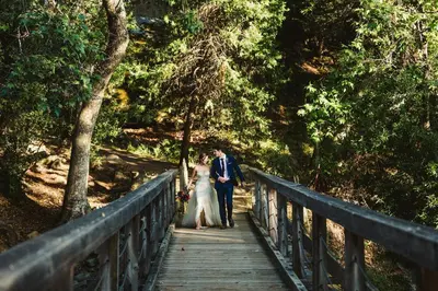a bride and groom walking on a bridge at Spacious and Luxurious Barn in Three Rivers, California in Three Rivers