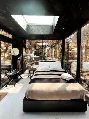 a bedroom with a large bed in a room with windows at Spacious and Luxurious Barn in Three Rivers, California in Three Rivers