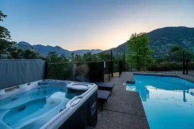 a hot tub in a backyard with a view of mountains at Sequoia Retreat - Scenic Pool, Hot Tub, & Trails in Three Rivers