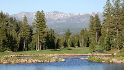 a golf course with a lake and mountains in the background at Pebble Place at Tahoe Donner by Tahoe Getaways - Pet Friendly, Single Level w HOA in Truckee