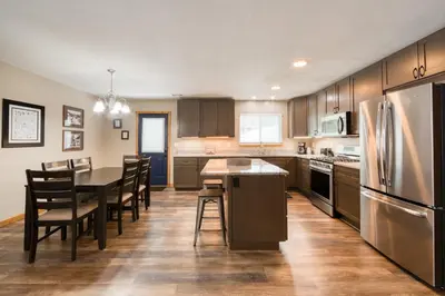 a kitchen with a table and chairs and a refrigerator at Pebble Place at Tahoe Donner by Tahoe Getaways - Pet Friendly, Single Level w HOA in Truckee