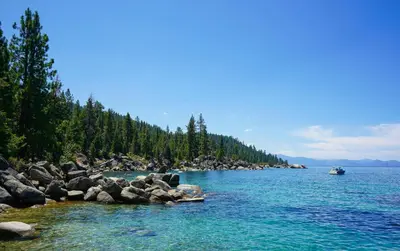 a boat on a river with rocks and trees at Mountain Escape - Lake Tahoe - Incline Village - Private Garage in Incline Village