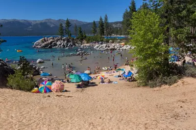 a crowd of people on a beach with umbrellas at Mountain Escape - Lake Tahoe - Incline Village - Private Garage in Incline Village