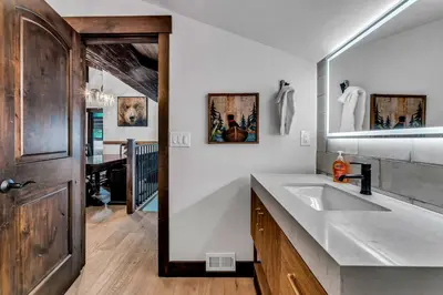 a white bathroom with a sink and a mirror at Fire & Ice Spacious Retreat with Hot tub and Fireplace in Truckee