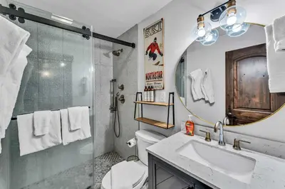 a bathroom with a shower and a sink and a mirror at Fire & Ice Spacious Retreat with Hot tub and Fireplace in Truckee