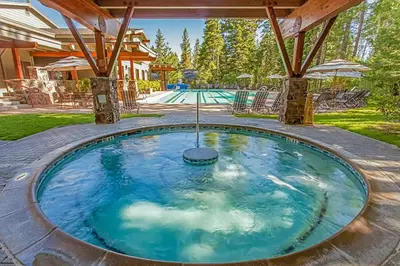 a large swimming pool with a blue water at Luxury Home Walk to Ski Lifts 6 Pools Food Private Hot-Tub Yard Fun Bunk Room in Truckee
