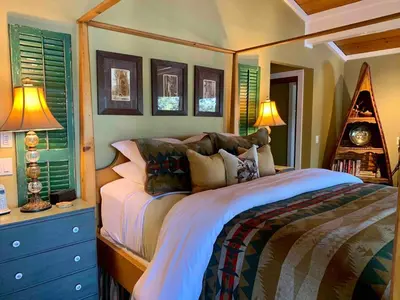 a bedroom with a bed and two lamps and windows at Lake Front-Near Yosemite-Pool Table-Private Dock -PML in Groveland