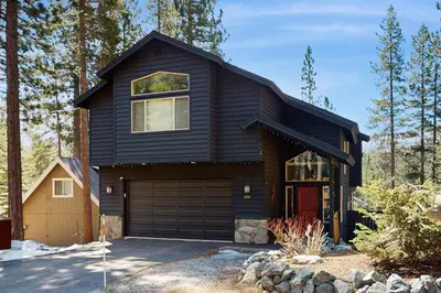 a black house with a garage at The Tahoe Timber House in South Lake Tahoe