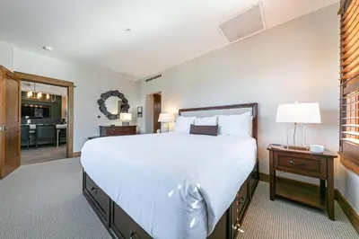 a bedroom with a large white bed and a bathroom at Iron Horse Lodge South 302 by East West Hospitality in Truckee