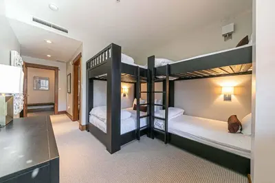 two bunk beds in a room with a desk at Iron Horse Lodge South 302 by East West Hospitality in Truckee