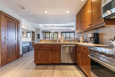 a large kitchen with wooden cabinets and stainless steel appliances at Iron Horse Lodge South 302 by East West Hospitality in Truckee