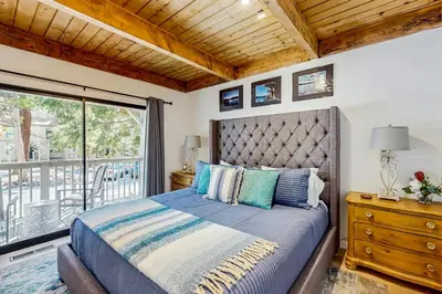 a bedroom with a large bed and a balcony at Lake Tahoe Adventure Base! Townhome with Pool Access in Wood Vista