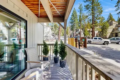 a porch with a chair and potted trees on it at Lake Tahoe Adventure Base! Townhome with Pool Access in Wood Vista