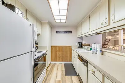 a kitchen with white appliances and wooden cabinets at Walk to Shops and Eats Mammoth Lakes Condo with Pool in Mammoth Lakes