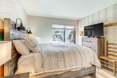a bedroom with a bed and a flat screen tv at Walk to Shops and Eats Mammoth Lakes Condo with Pool in Mammoth Lakes