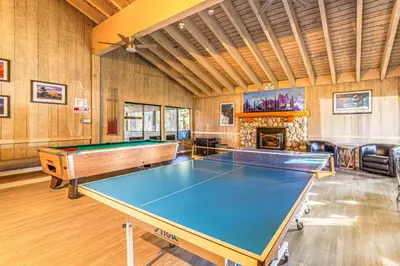 a room with a ping pong table and a fireplace at Walk to Shops and Eats Mammoth Lakes Condo with Pool in Mammoth Lakes