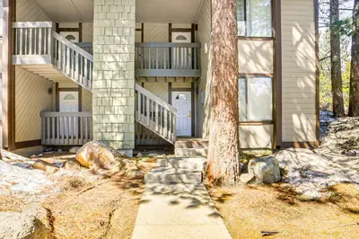 a house with stairs and a tree in front of it at Walk to Shops and Eats Mammoth Lakes Condo with Pool in Mammoth Lakes