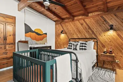 a bedroom with a bed and a wooden wall at Modern 2 Bedrm Kids, Dog, Hot Tb, Game Room, 9 min Bass Lake in Oakhurst