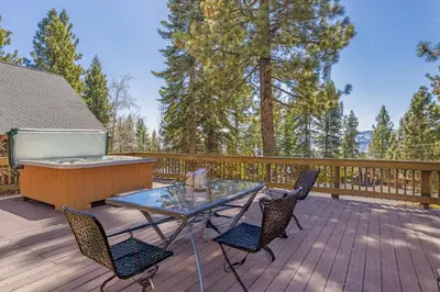 a table and chairs on a deck with a hot tub at Spacious 5BDR Lake View Home w Hot Tub Close to Slopes Town Beach in Tahoe City