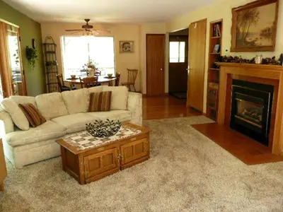 a living room with a white couch and a fireplace at Gorgeous Cabin Rental with Spacious Furnished Deck in Pioneer, California in Pioneer