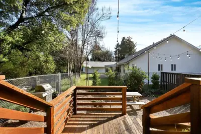 a wooden deck with a bench and a fence at Inspiring Cottage Rental for a Vacation in California Wine Country in Lockeford