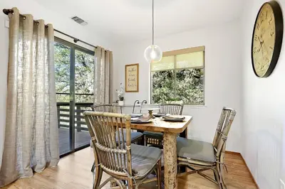 a dining room with a table and chairs and a clock at Inspiring Cottage Rental for a Vacation in California Wine Country in Lockeford