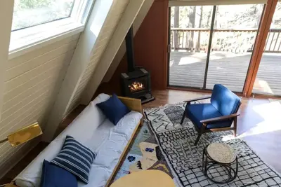a living room with a couch and a fireplace at Stunning A-Frame Cabin Rental for Four Guests in Arnold, California in Arnold