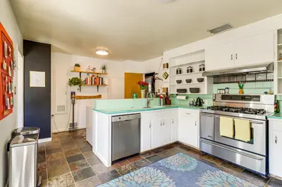 a large kitchen with white cabinets and blue appliances at 24 Mi to Slopes! Family Reno Home with Outdoor Oasis in Reno